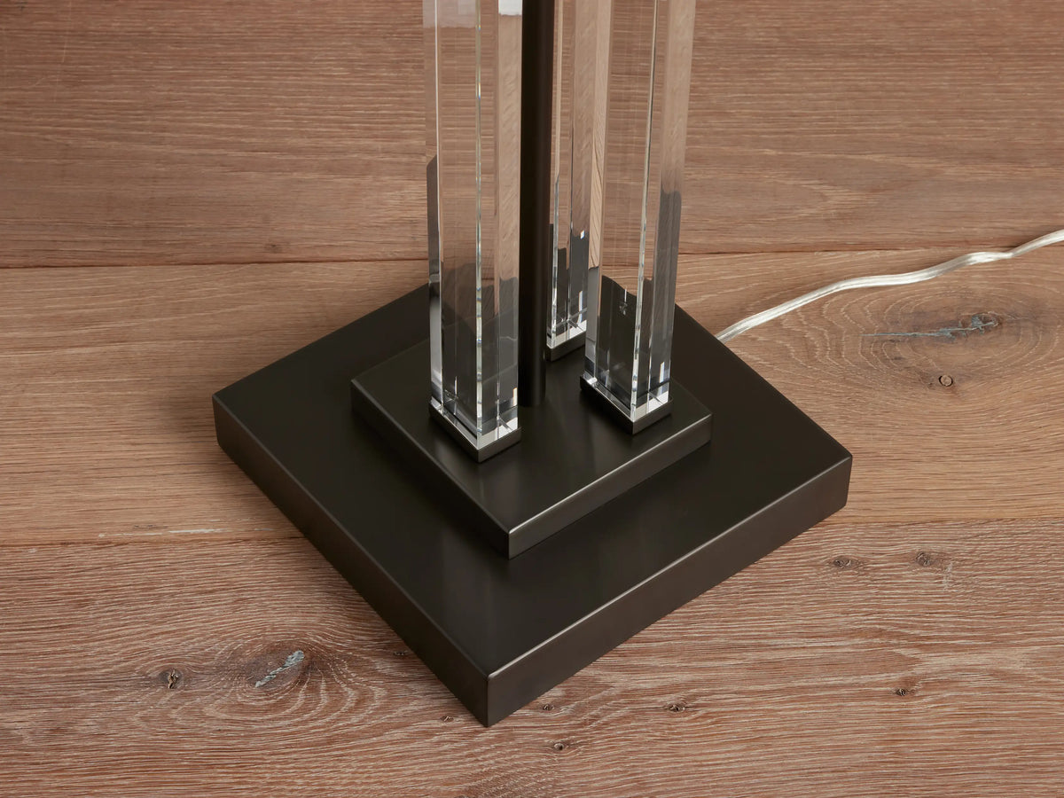 Dawson Floor Lamp base with crystal pillars on a dark square iron platform, clear cord visible on a wooden floor.
