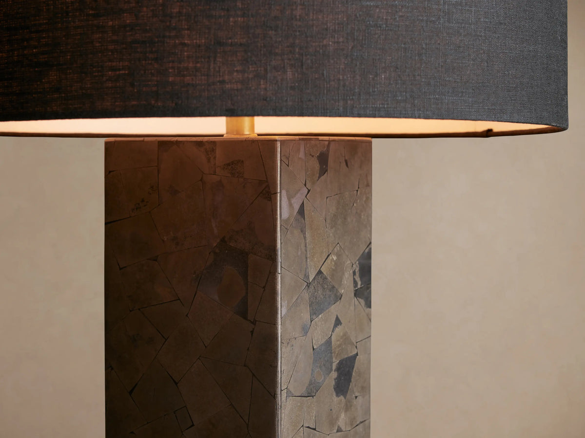 Pyrite Table Lamp: tall rectangular base with metallic pyrite shards, black linen cylindrical shade, on a rustic wooden table.