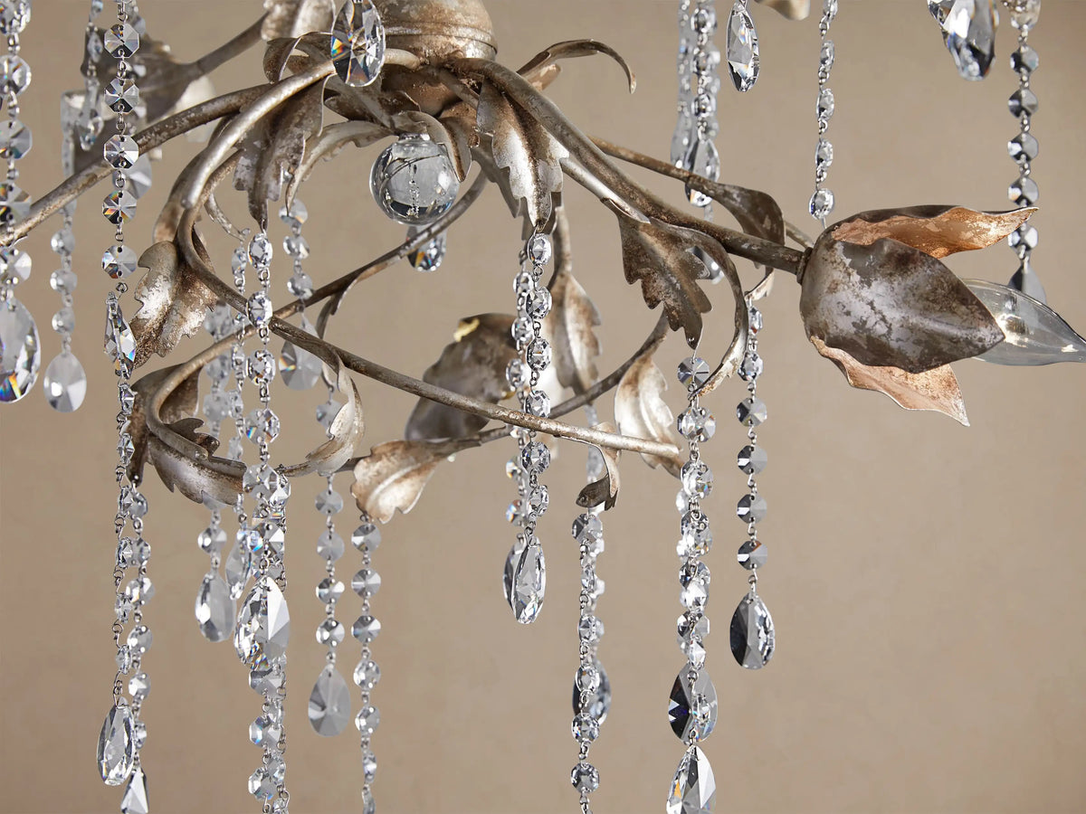 Viticcio Round Chandelier: silver-finished iron branches with warm-toned petal light covers & clear dangling faceted crystals.