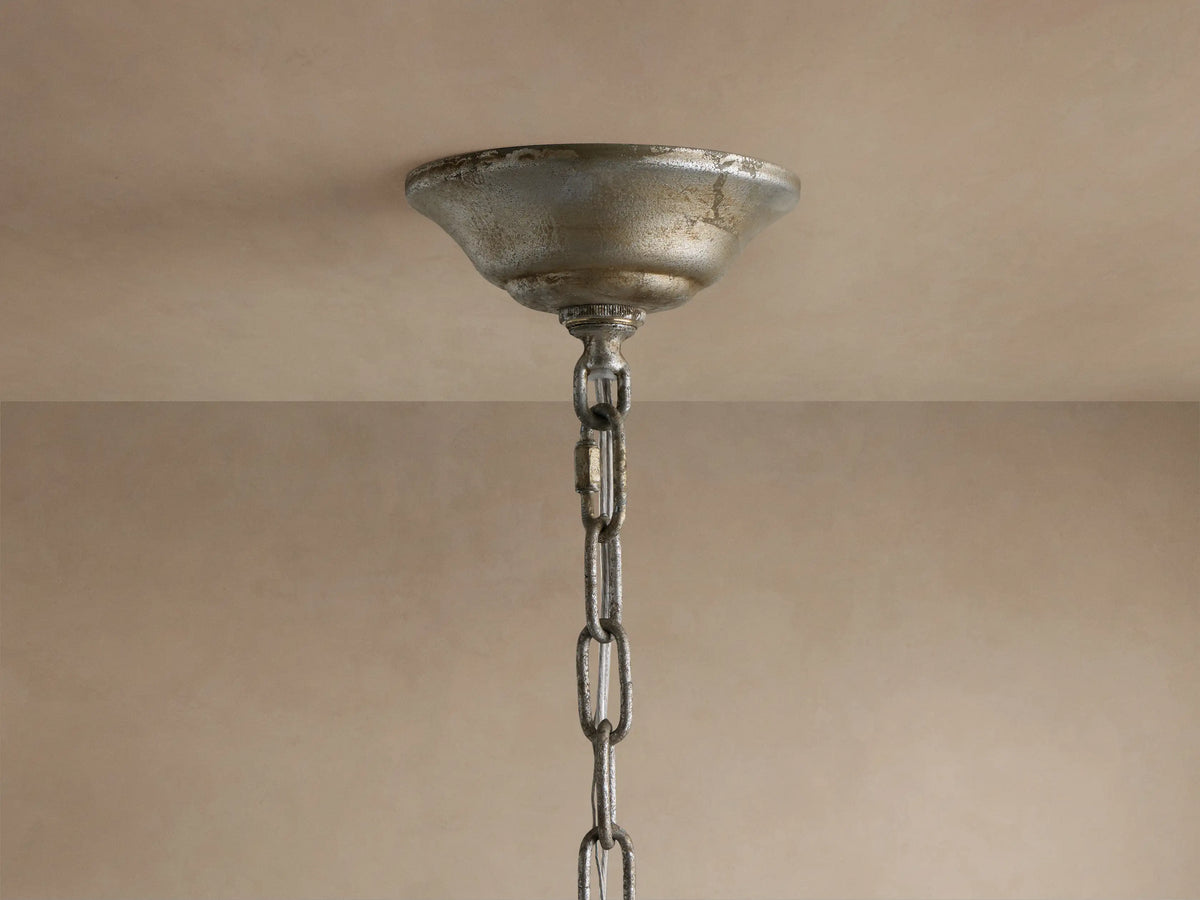 Close-up of Claudette Chandelier: golden-silver leaf frame, clear Italian glass crystals, and white candle-style light bulb.