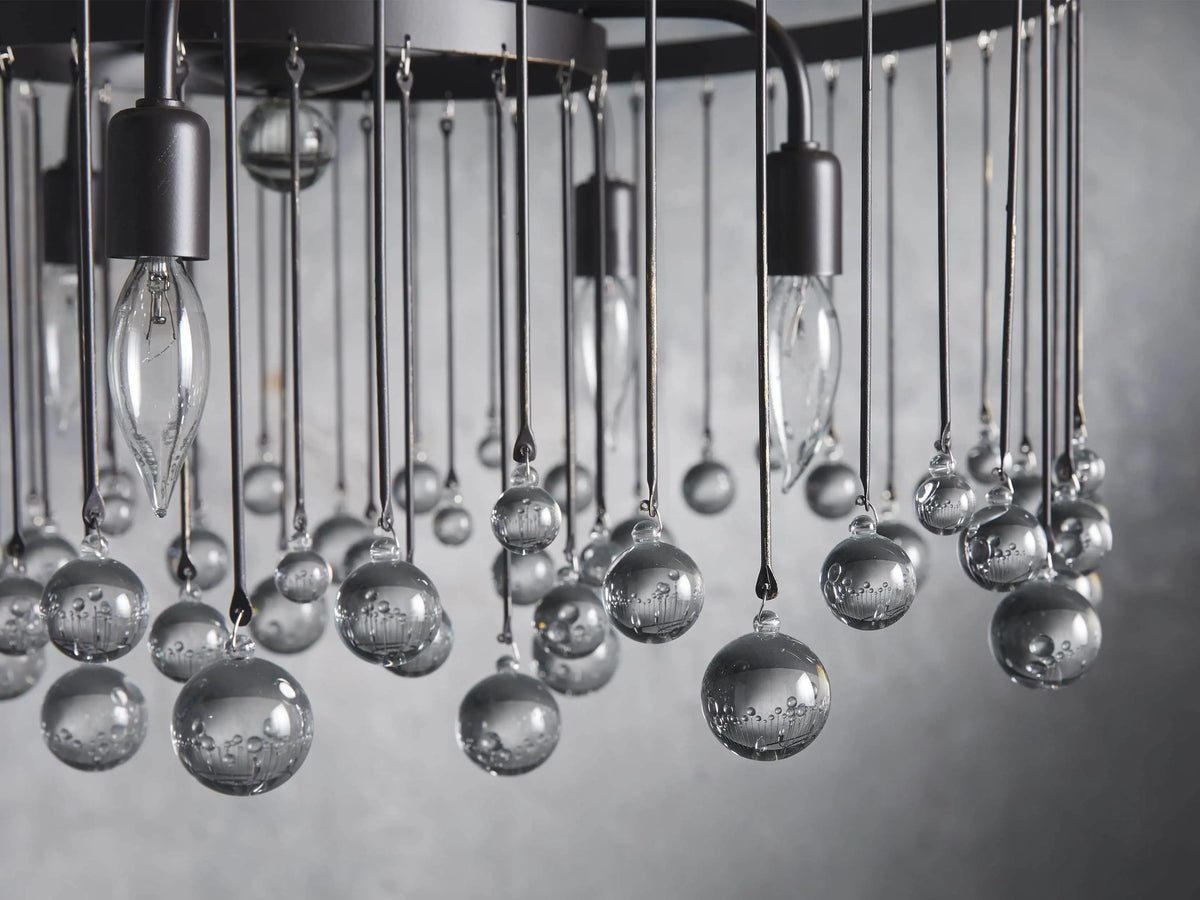 Aubrey Round Chandelier's ceiling mount with a dark brown iron finish, attached to a sturdy chain descending downwards.