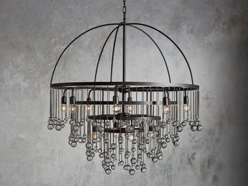 A round chandelier with a dark iron frame, featuring cascading glass orbs and five visible lit bulbs, hanging from a chain.