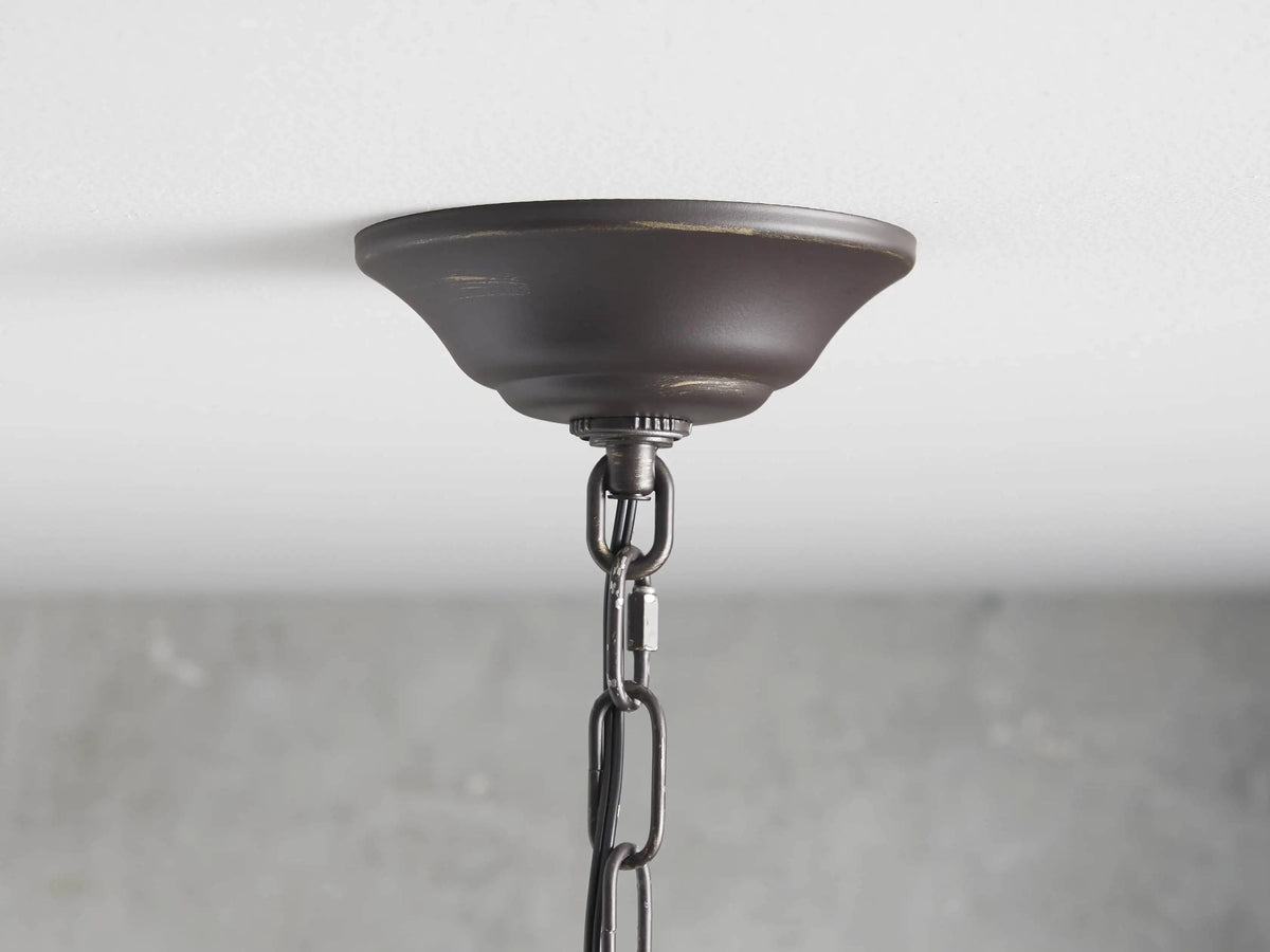 Aubrey Round Chandelier with dark iron rings, featuring hanging glass balls and lit bulbs creating an elegant ambiance.