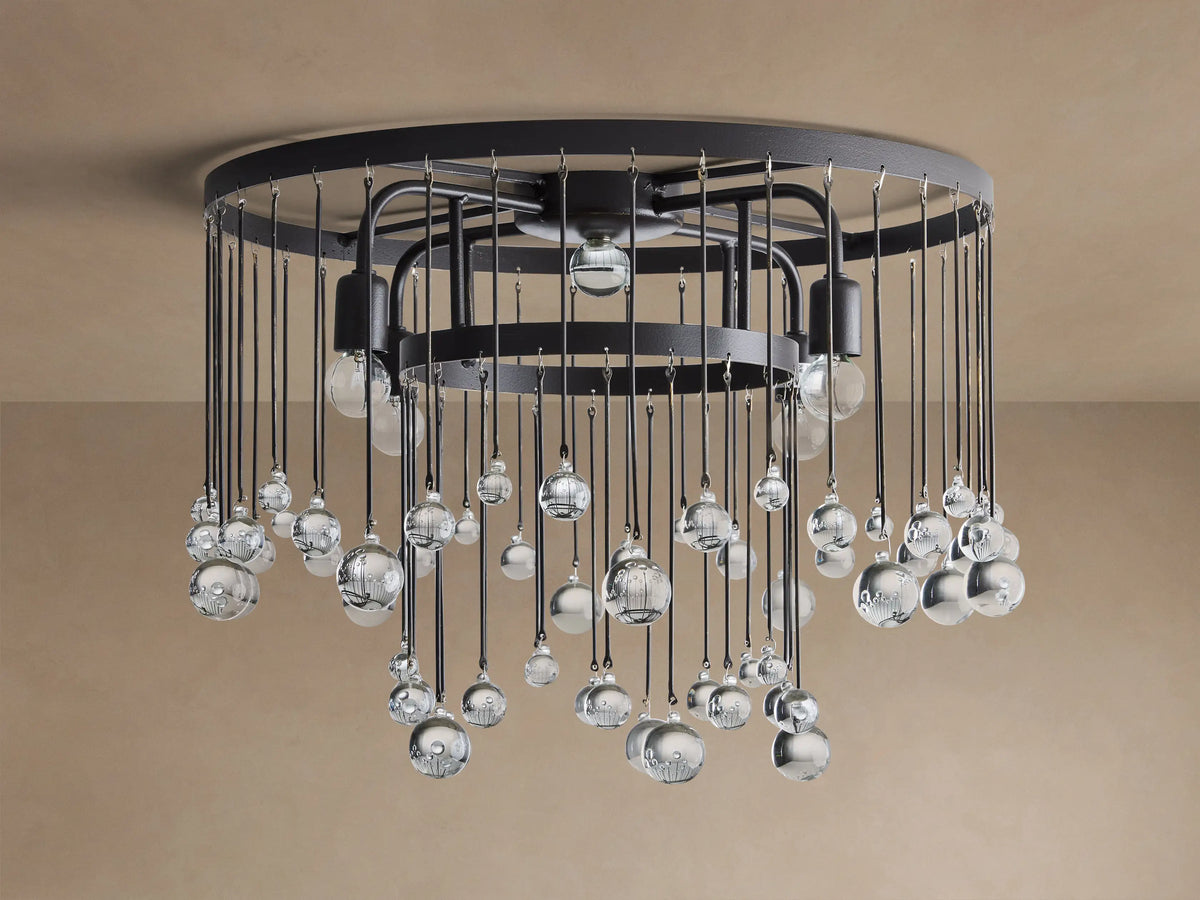 Aubrey Flush Mount with a dark metal frame, numerous clear glass bubbles hanging from wires, and four glowing bulbs, against a beige ceiling.