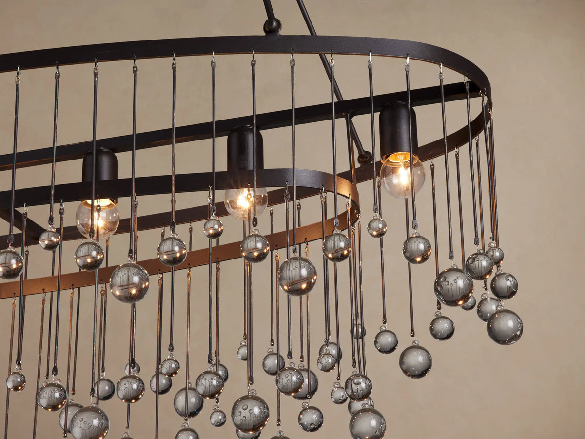Aubrey Oval Chandelier: Dark iron oval frame with numerous smoky gray glass beads hanging at varied lengths against a light wall.