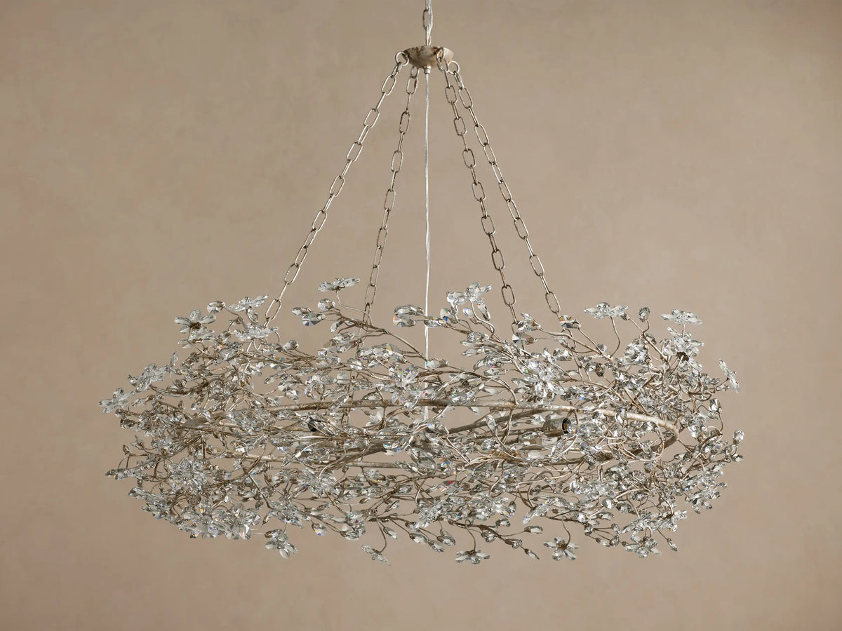 Fiore Crown Chandelier: Ornate silver-finished metal frame, adorned with numerous small, clear crystal flowers, hanging from chains.