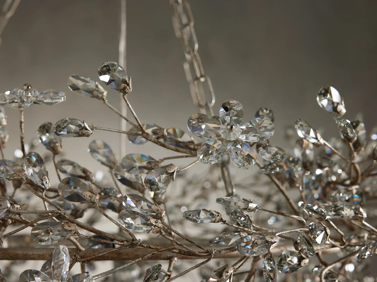 Close-up of the Fiore Crown Chandelier with antiqued silver/gold branches adorned with sparkling, faceted clear crystal flowers and leaves.