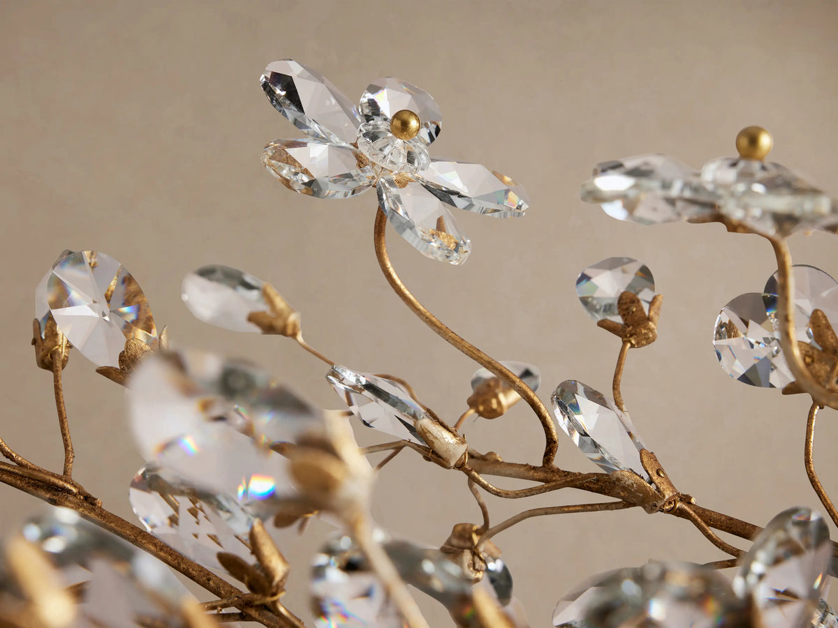 Fiore Linear Chandelier: gold-toned, horizontal fixture with delicate branches adorned with clear crystal flowers, hanging from chains.