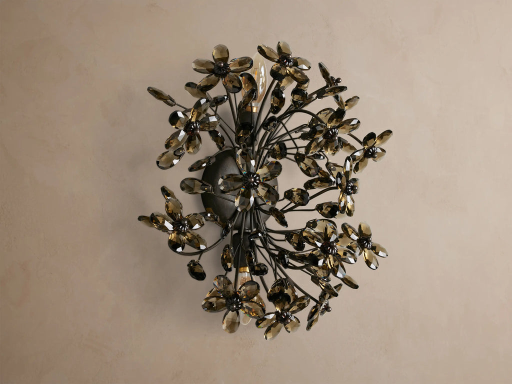 Fiore Sconce: Wall-mounted light with dark metal branches holding numerous smoky brown crystal flowers, radiating warm light.