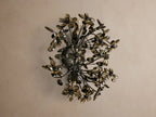 Fiore Sconce: Wall-mounted light with dark metal branches holding numerous smoky brown crystal flowers, radiating warm light.