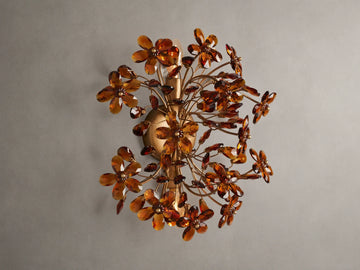 Fiore Sconce with a gold antiqued leaf design, featuring amber-colored flower-like structures radiating outward from a central base.