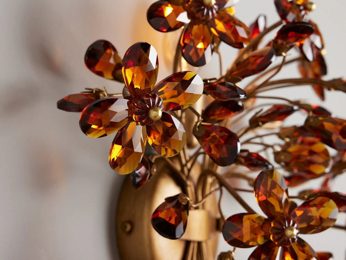Fiore Sconce in solid iron with hand-applied antique finish features gold and amber floral design on a light background.
