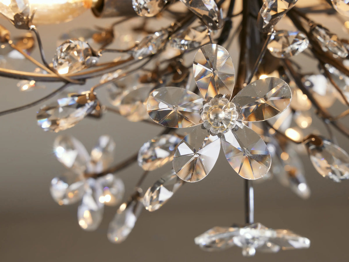 Fiore Flush Mount: Dark iron branches sprout clear crystal flowers & teardrops, sparkling against a beige ceiling.