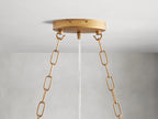 Alt text: Close-up of the Fiore Linear Chandelier featuring hand-applied antique leaf design, with amber-colored crystal accents and gold-finished iron branches.