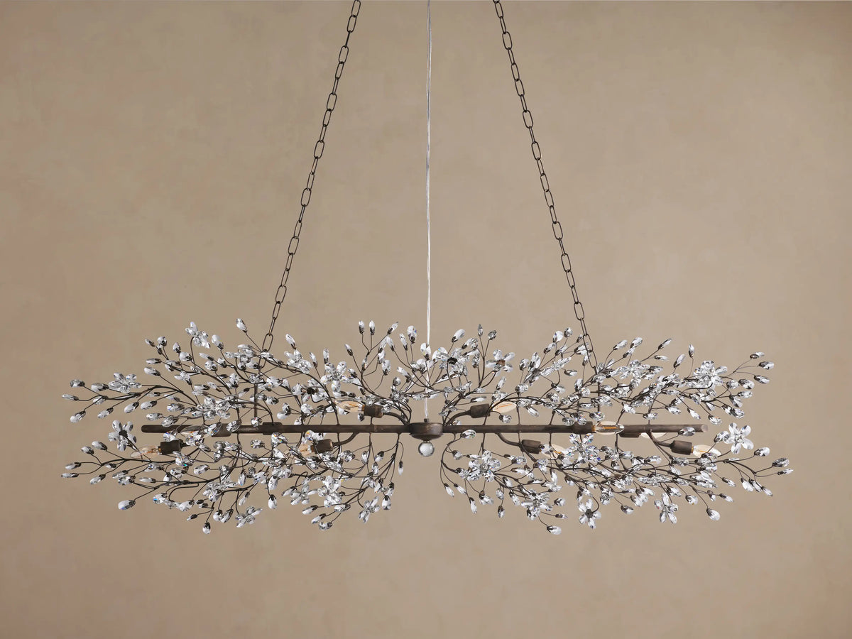 Fiore Linear Chandelier: dark metal frame with delicate branches, sparkling clear crystal flowers, and glowing bulbs, suspended.