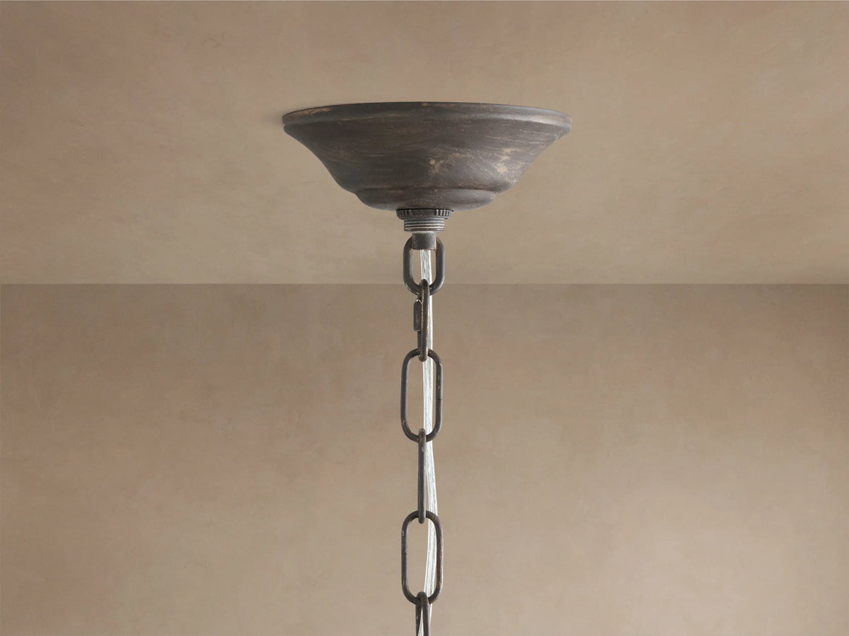Detailed Fiore Linear Chandelier close-up: clear crystal flower & teardrop accents on dark antiqued bronze metal, warm bulb glow.