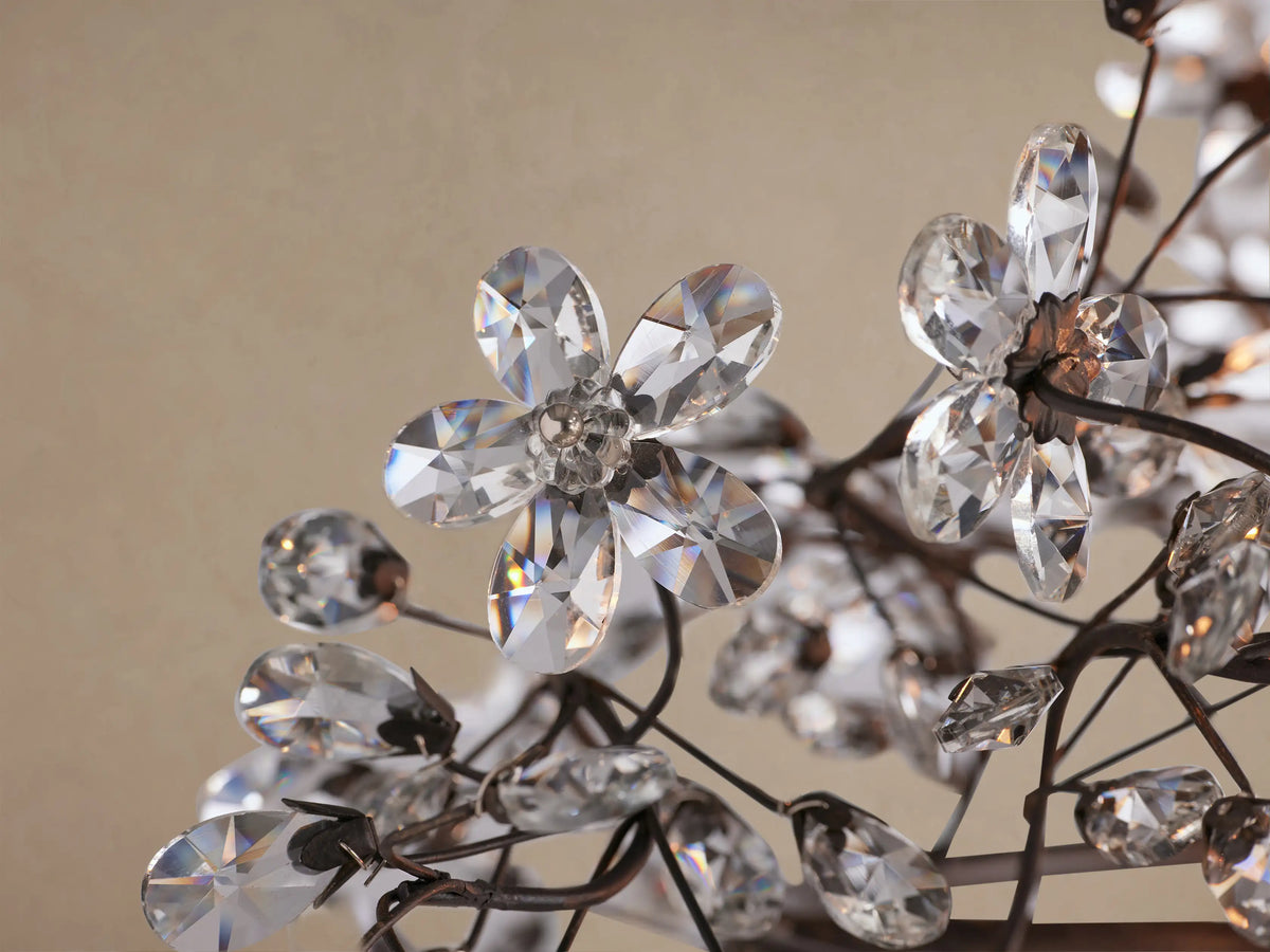 Fiore Oval Chandelier, horizontal dark metal frame adorned with clear crystal leaves and buds, suspended by chains.