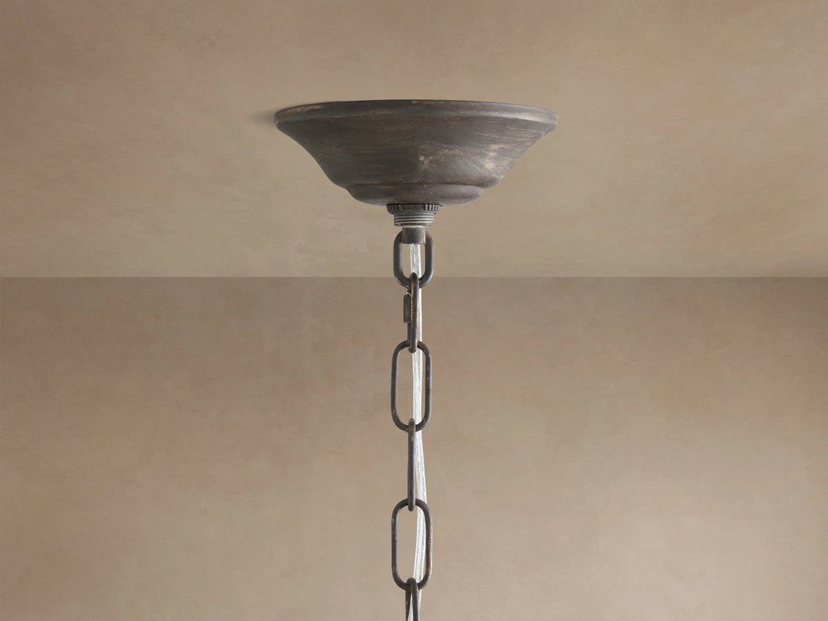 Fiore Crown Chandelier: Close-up of rustic dark bronze canopy and chain hanging from a light beige ceiling.