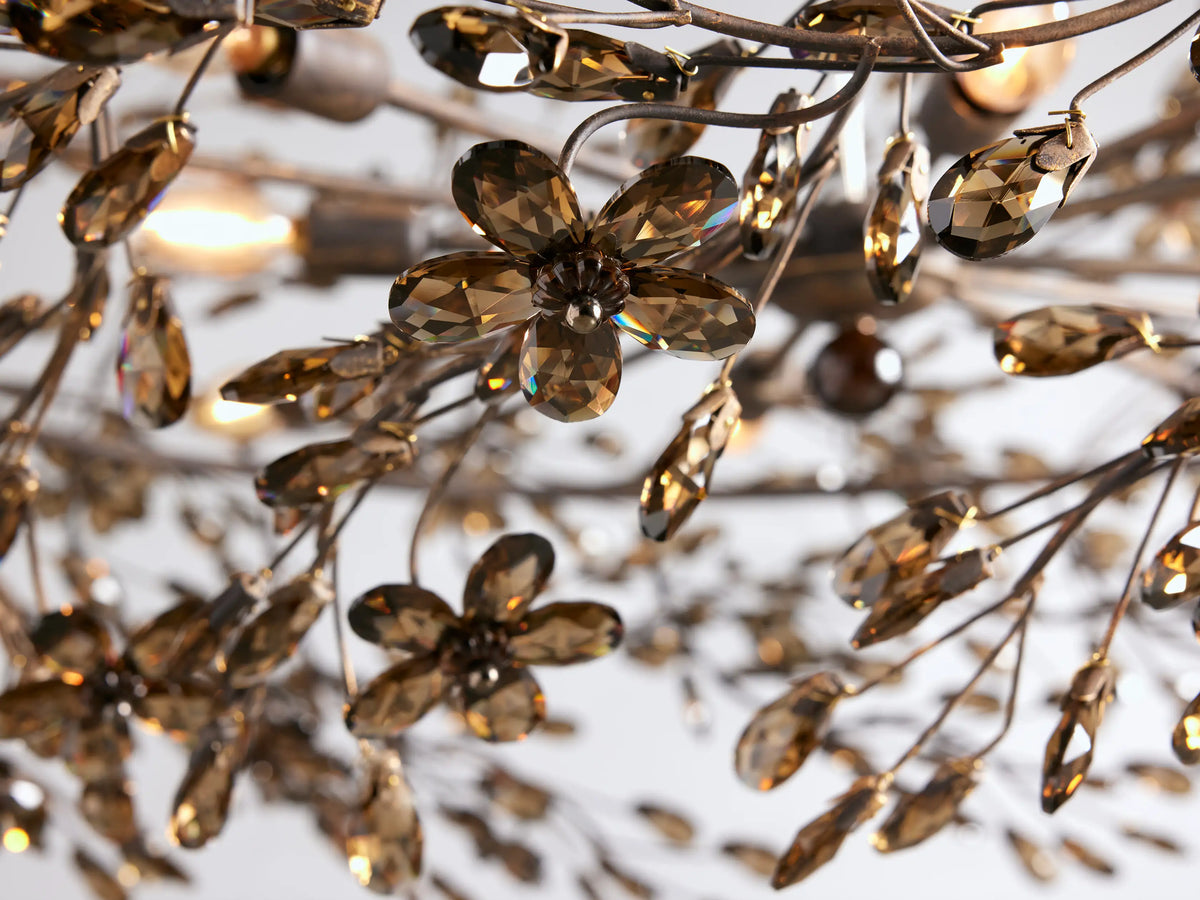 Fiore Crown Chandelier, a circular antique silver frame adorned with numerous sparkling amber crystal leaves, hanging from chains.