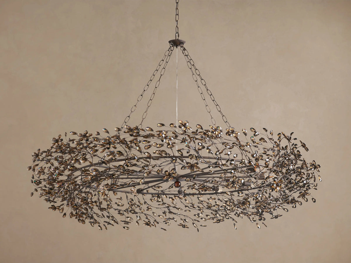 Fiore Crown Chandelier: Oval dark metal frame adorned with numerous amber crystal leaves arranged like branches, hanging.