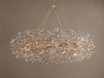 Gold Fiore Crown Chandelier, an oval-shaped light fixture adorned with countless clear crystal flowers, hanging from chains.