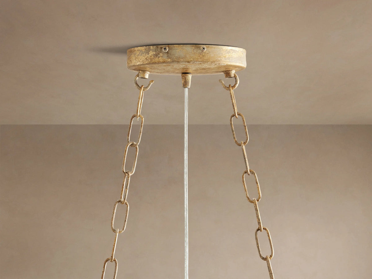 Close-up of Fiore Oval Chandelier: gold branches adorned with clear, sparkling crystal flowers and teardrop-shaped gems.