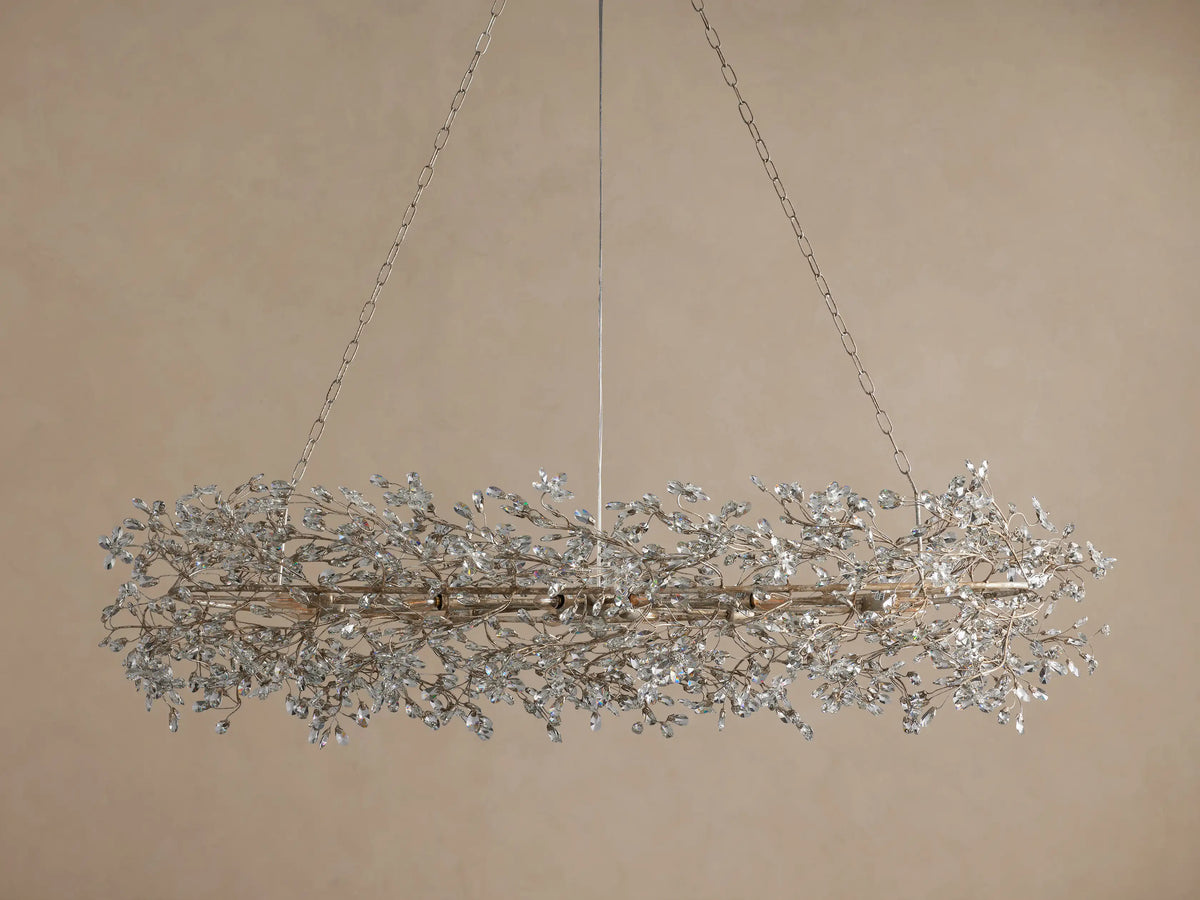 Fiore Oval Chandelier, antiqued silver iron with sparkling clear crystal leaves, hanging from chains against a neutral wall.