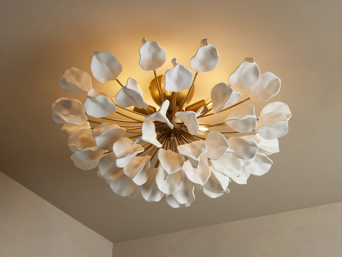 Lunaria Flush Mount with ceramic leaves resembling petals, arranged around golden iron stems, emitting warm light.