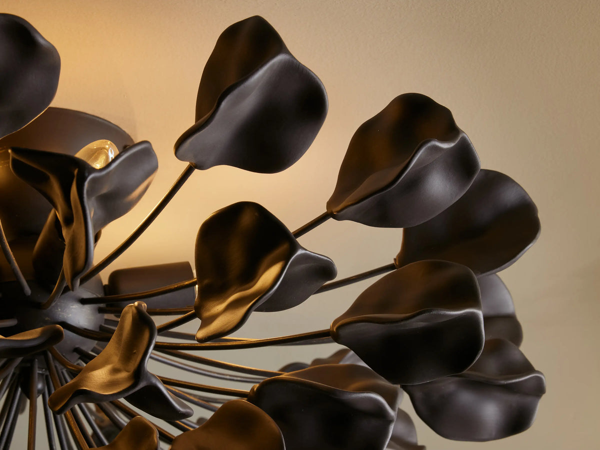 Flush mount light fixture with dark iron finish, 56 ceramic leaves in a floral arrangement, attached to ceiling.
