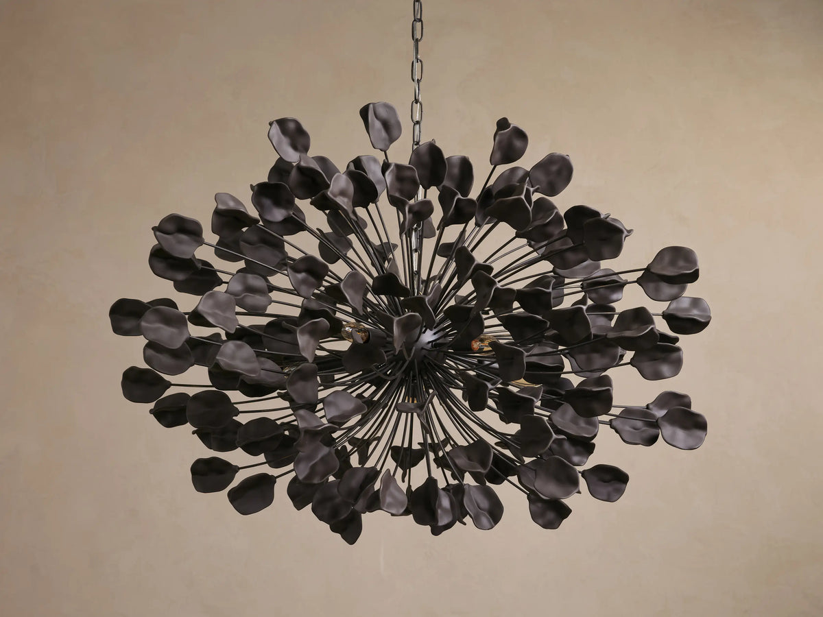 Lunaria Chandelier with spherical design, iron structure, and 160 ceramic leaves. Warm light emanates, casting intricate shadows.