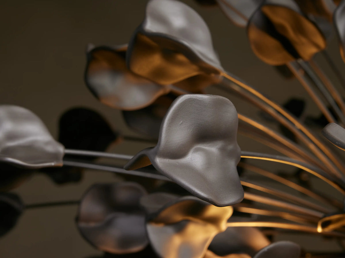 Lunaria Chandelier with iron structure and numerous curved ceramic leaves. Illuminated from within, displaying warm light reflections.