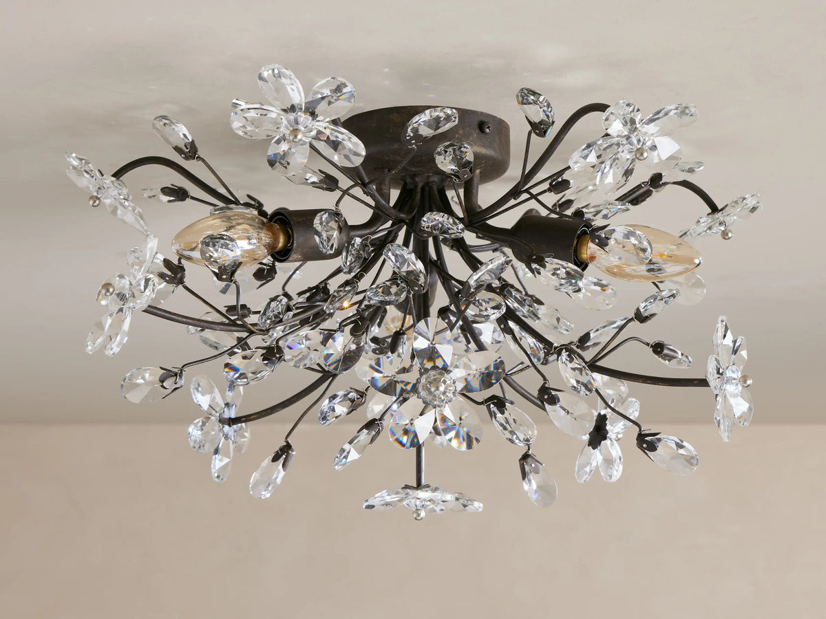 Fiore Flush Mount ceiling light with dark bronze finish, clear crystal flowers & teardrops, warm glowing bulbs.