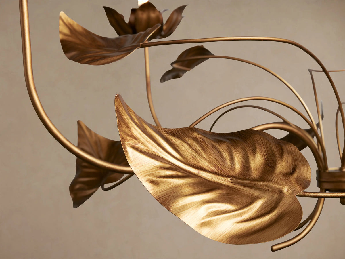 Ninfea Chandelier, an ornate antiqued gold fixture with five detailed lily-like flower bulb holders and numerous delicate leaves.