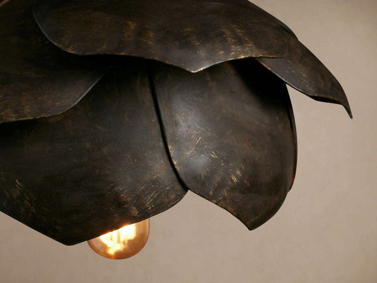 Lorca Pendant, a dark, layered flower-shaped fixture with antique brass/bronze tones, hanging from a cord.