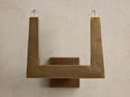 Front view of textured bronze U-shaped wall sconce with two glowing bulbs.