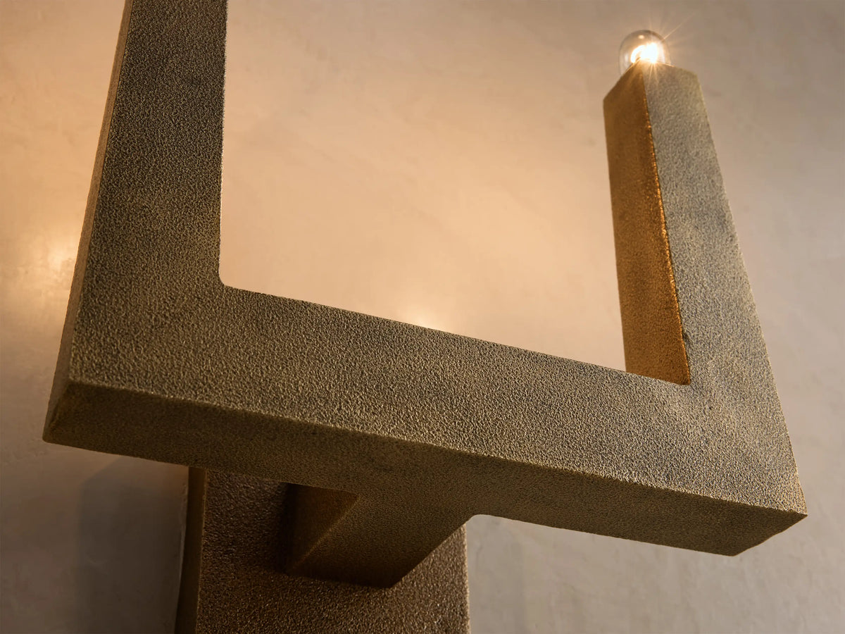 Front view of a gold textured U-shaped wall sconce with two exposed clear light bulbs.