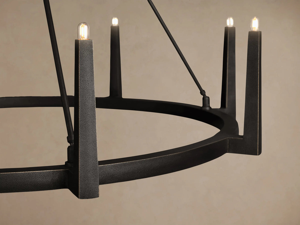 Emmet Round Chandelier with dark, antiqued bronze finish. It features multiple glowing bulbs in upright tapered holders, suspended.