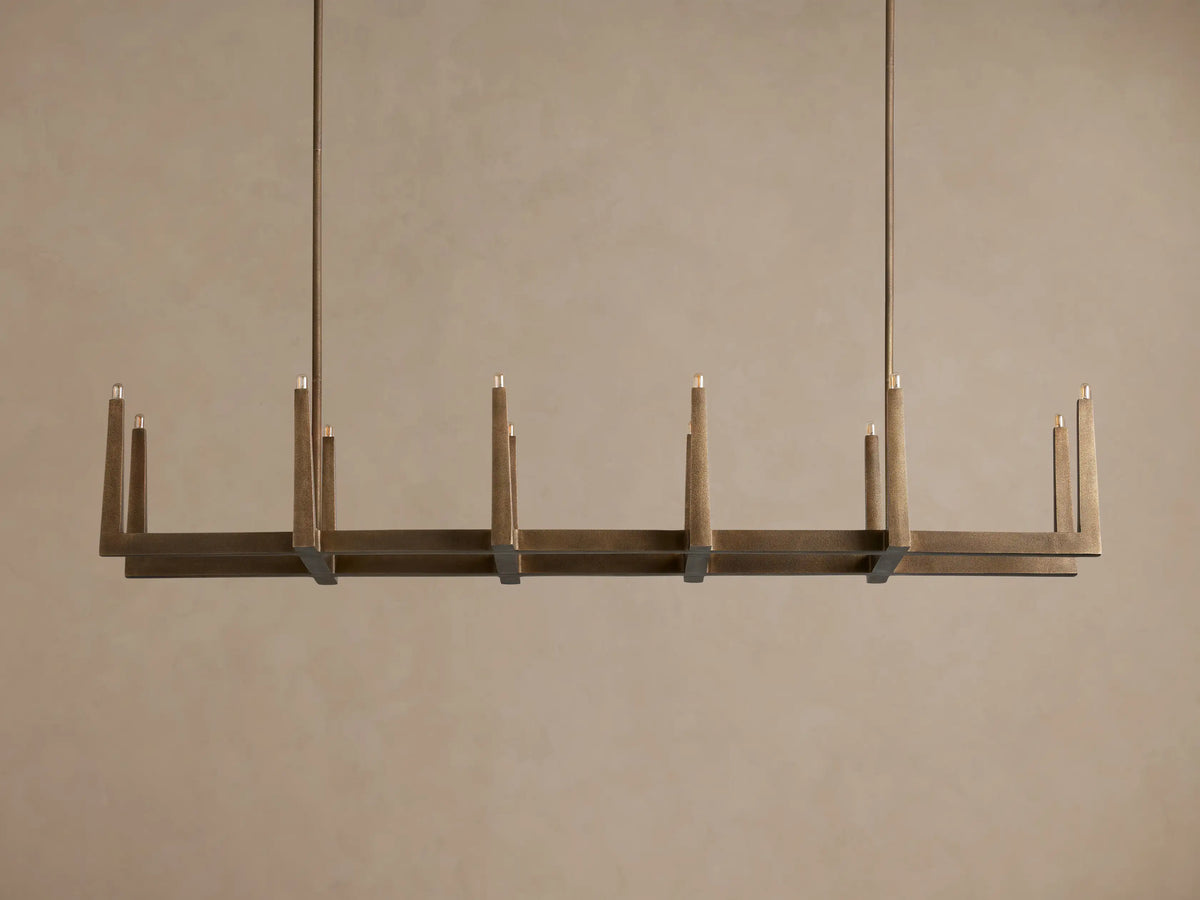 Emmet Linear Chandelier in antiqued brass, hanging horizontally. Rectangular frame features 10 lit, candelabra-style bulbs.