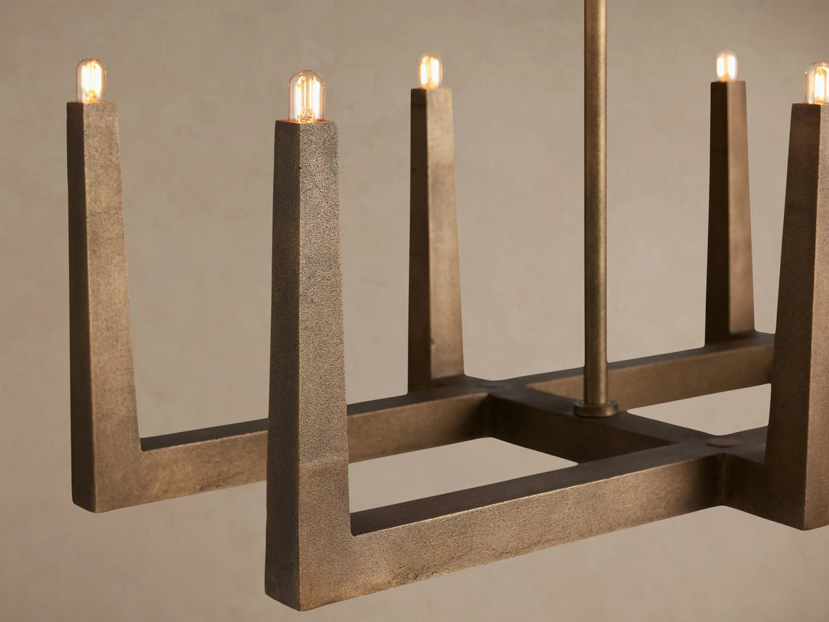 Emmet Linear Chandelier: Antiqued brass finish, rectangular frame with 8 upright light stems, against a light background.